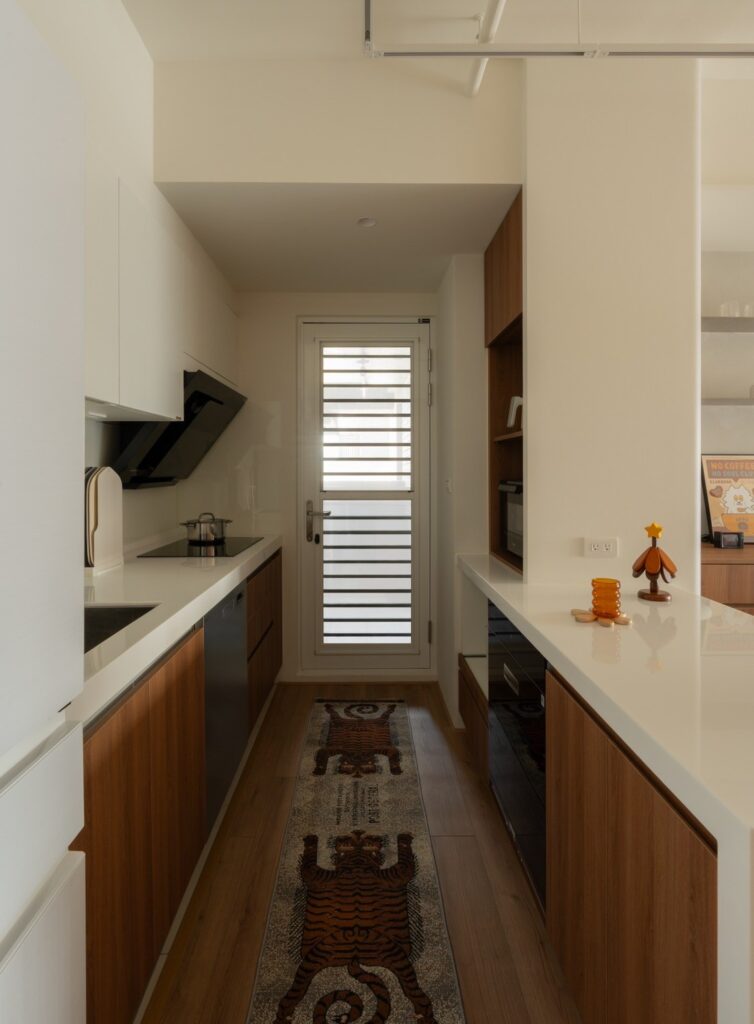 廚房延續了建商原有的廚具配置，透過改色整合整體色調，並在中島區加設電器櫃。